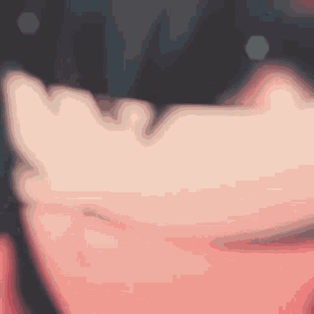 a close up of a person 's face with a blurred background .