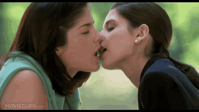 two women kissing in front of a movieclip.com screen