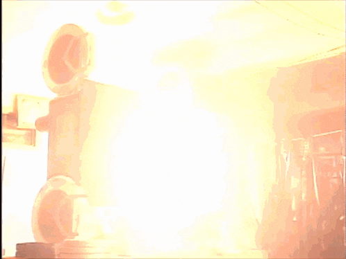 a large fire is burning in a dark room with smoke coming out of it