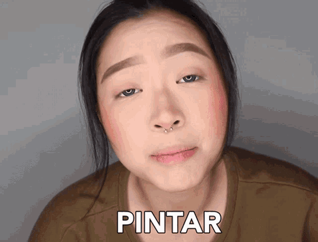 a woman with a nose ring is wearing a shirt that says pintar on it