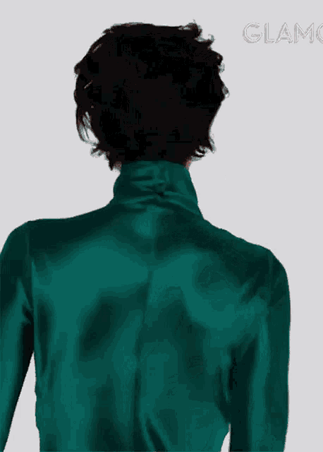 a woman 's back is shown in a green turtleneck sweater
