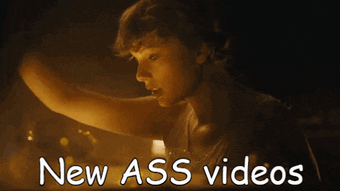 a woman in a dark room with the words " new ass videos " on the bottom