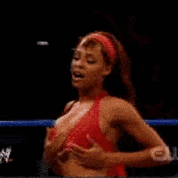 a woman in a pink bikini is standing in a wrestling ring