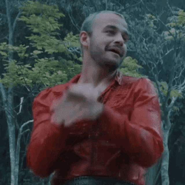 a man in a red jacket is standing in the rain