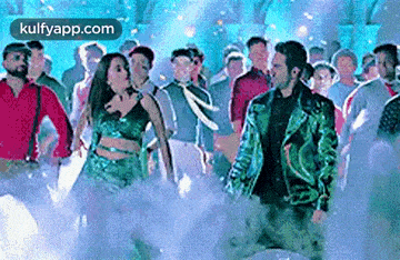 a group of people are dancing in a club with smoke coming out of the ceiling .
