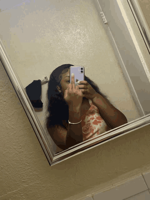 a woman takes a picture of herself in a mirror