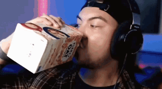 a man drinking from a box of oatmeal