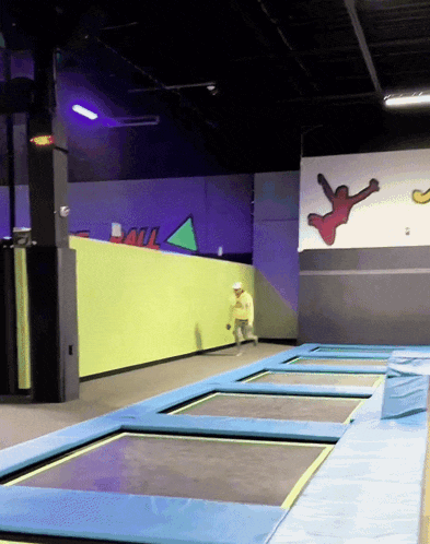 a man stands on a trampoline in front of a wall that says " soul " on it
