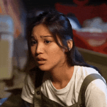a woman in overalls is making a funny face