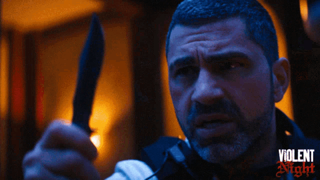 a man holding a knife with violent night written on the bottom right