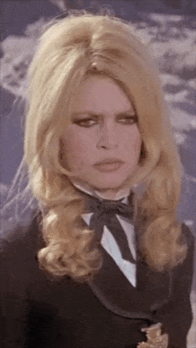 a woman wearing a tuxedo and bow tie looks at the camera