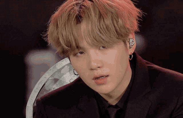 a close up of a person wearing a black suit