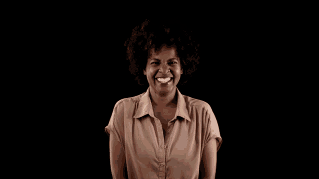 a woman in a brown shirt is smiling with her mouth open