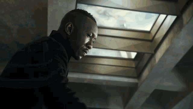 a man in a black suit looks up at the sky