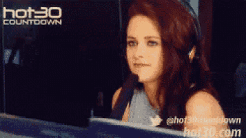 a woman is sitting in front of a hot 30 countdown screen