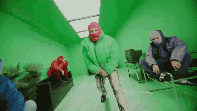 a man wearing a green jacket and a pink ski mask