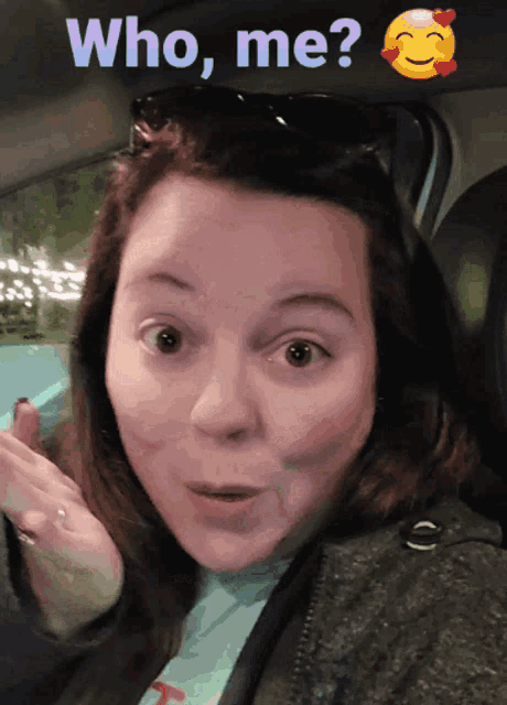 a woman in a car with a smiley face and the words " who me " above her