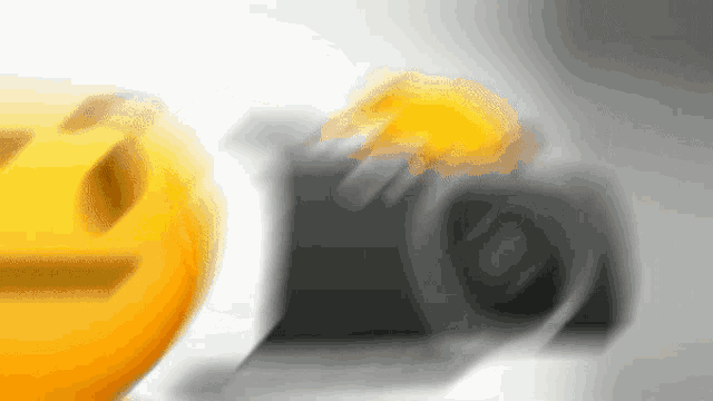 a blurry picture of a camera with a yellow smiley face in the background