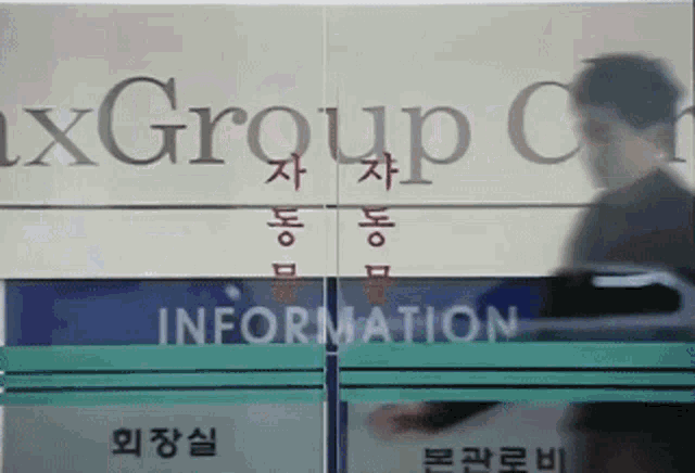 a man walking in front of a sign that says " information "