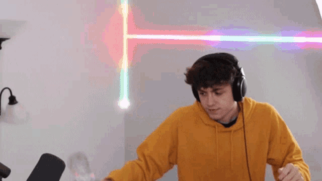 a young man wearing headphones is dancing in front of a lamp