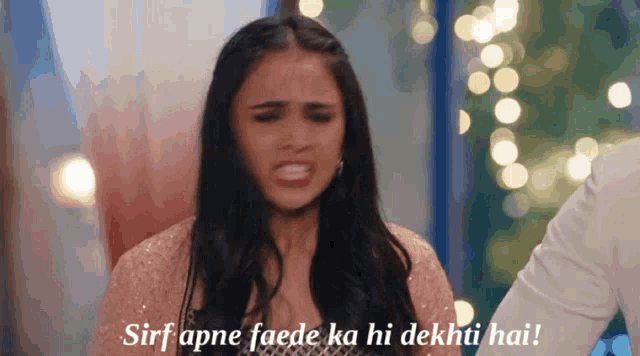 a woman is making a funny face with the words sirf apne faede ka hi dekhti hai written below her