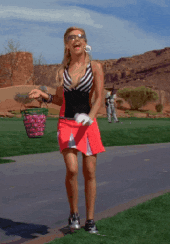 a woman in a red skirt carrying a basket full of golf balls