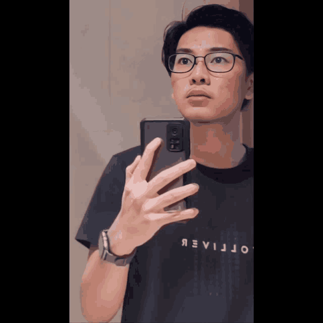 a man wearing glasses takes a selfie with a cellphone