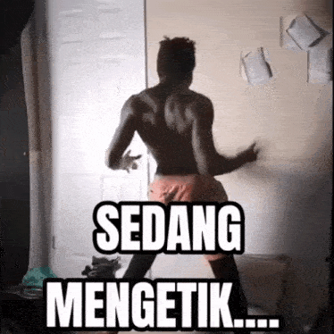 a shirtless man is dancing in front of a door with sedang mengetik written on it