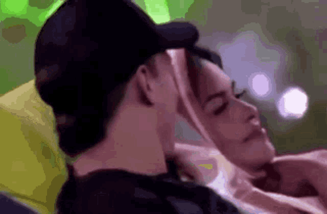 a man and a woman are laying on a couch .