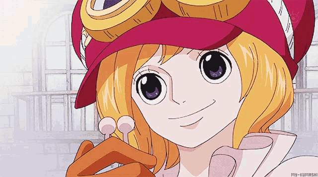 a girl wearing a pink hat and goggles is smiling and holding a lollipop