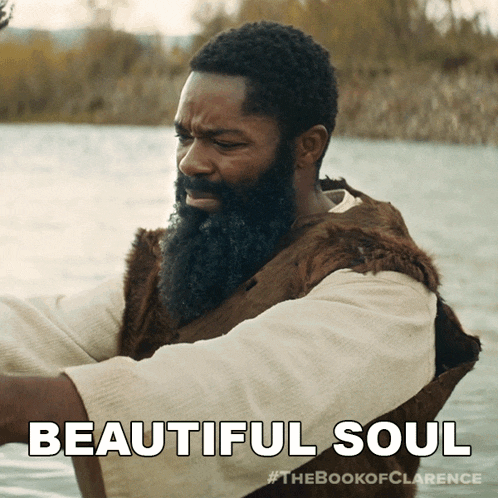 a man with a beard is sitting in the water with the words beautiful soul below him