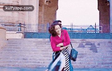 a man is carrying a woman on his shoulders while walking down stairs .