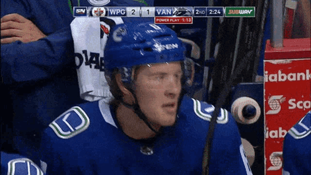 a hockey player wearing a blue helmet stands in front of a scoreboard that says subway