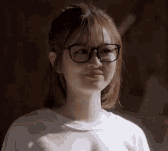 a close up of a woman wearing glasses and a white sweater .