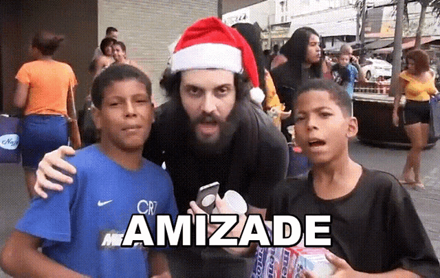 a man wearing a santa hat is posing for a picture with two young boys and the word amizade is on the bottom right