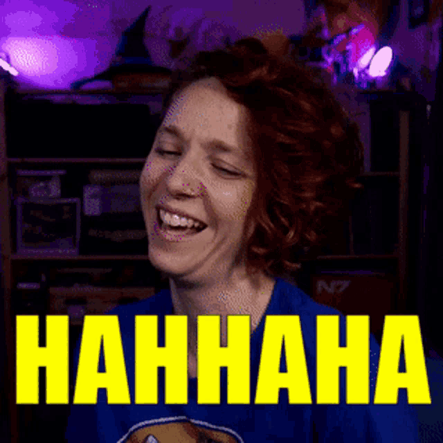 a woman is laughing in front of a sign that says nahhaha