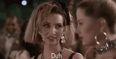 two women are standing next to each other at a party and one of them is wearing a wig .