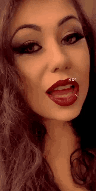 a close up of a woman 's face with red lips and a nose ring that says no
