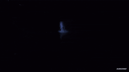 a person is standing in a dark room surrounded by smoke and fog .