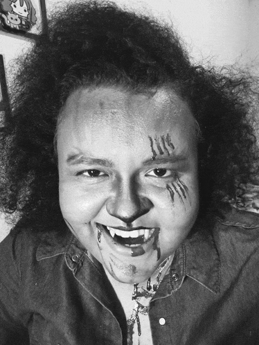 a black and white photo of a person with their face painted to look like a tiger