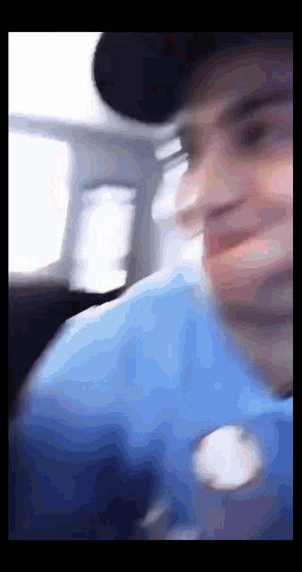 a blurry picture of a man wearing a blue shirt and hat