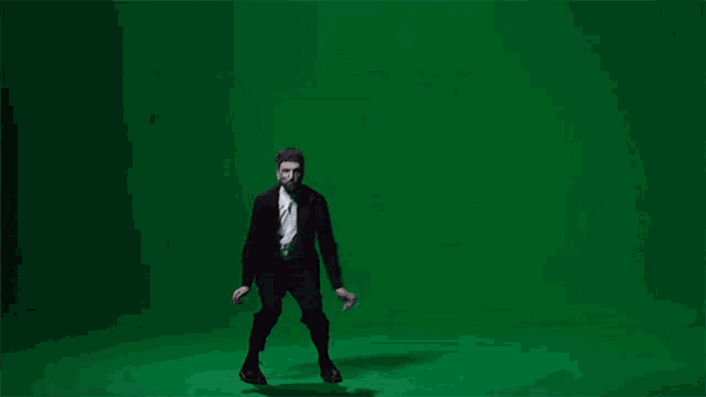 a man in a suit dancing on a green screen