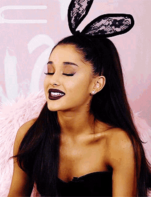 a woman wearing bunny ears and a black top smiles