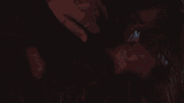a man and a woman are kissing in the dark .