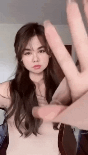 a woman is making a peace sign with her hands .