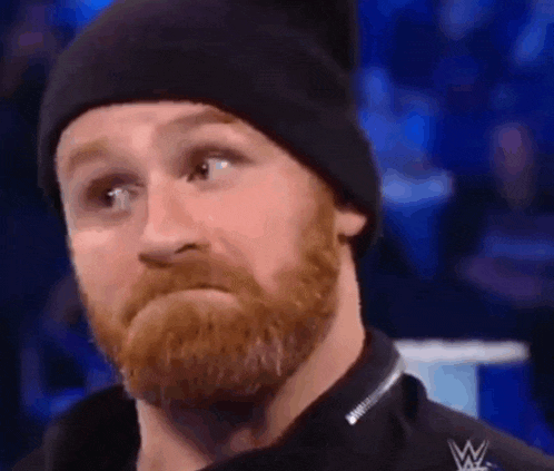 a man with a beard is wearing a black beanie and a black shirt .