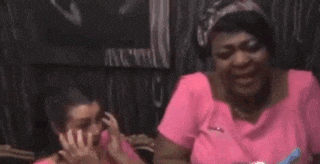 a woman in a pink shirt is sitting next to another woman in a pink shirt .
