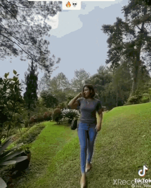 a woman is walking on a lush green field .