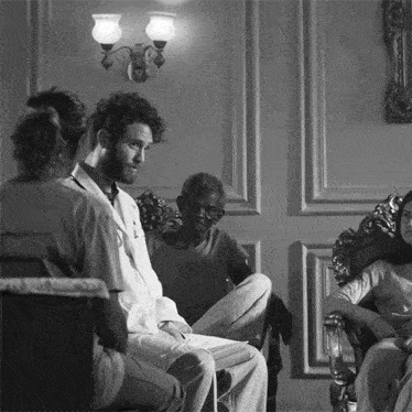 a black and white photo of a group of people sitting around a table