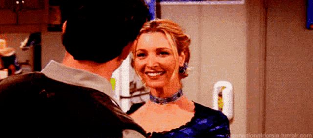 a man and woman are standing next to each other and the woman is smiling .